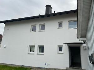 un edificio blanco con una puerta a un lado en Ferienapartment Allgäu-Idyll, en Dietmannsried