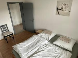 1 dormitorio con 1 cama y 1 silla en Ferienapartment Allgäu-Idyll, en Dietmannsried