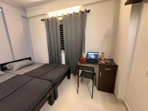 1 dormitorio con 1 cama y escritorio con ordenador portátil en Bangalore Stays, en Bangalore