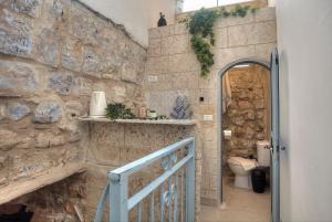 bagno con parete in pietra e servizi igienici. di קשתות - מתחם אבן בצפת העתיקה - Kshatot - Stone Complex in Old Tzfat a Safed