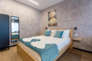 sypialnia z dużym łóżkiem z niebieskimi poduszkami w obiekcie Social Lodge - Hollywood w Funchal