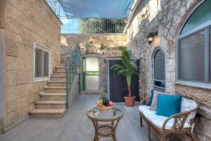 un patio con sofá, mesa y escaleras en קשתות - מתחם אבן בצפת העתיקה - Kshatot - Stone Complex in Old Tzfat en Safed