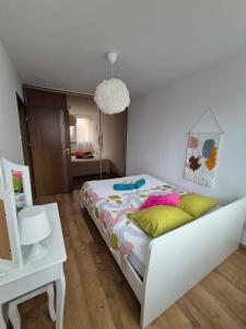 a bedroom with a white bed with yellow pillows at Stacja Kudowa in Kudowa-Zdrój