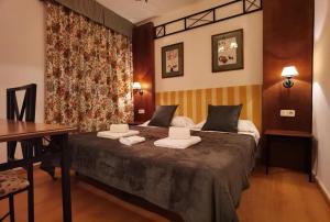une chambre d'hôtel avec un lit et des serviettes. dans l'établissement HOSTAL RURAL ALTO TAJO POVEDA, à Poveda de la Sierra