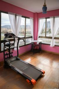 un gimnasio con cinta de correr en una habitación con ventanas en Casa los Arcos, en Trespaderne