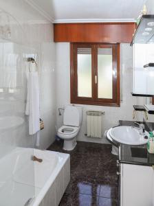 a bathroom with a tub and a toilet and a sink at Casa los Arcos in Trespaderne