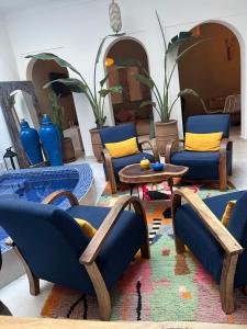 ein Wohnzimmer mit blauen Stühlen und einem Tisch in der Unterkunft RIAD JULILU PRIVATISE in Marrakesch