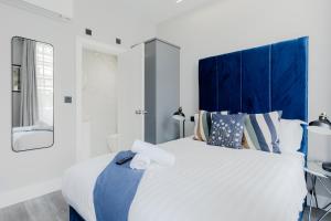 sypialnia z dużym łóżkiem z niebieskim zagłówkiem w obiekcie London Central Studios w Londynie