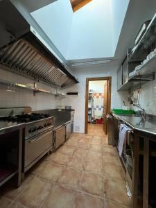 a large kitchen with stainless steel appliances and a tile floor at Casa Rural La Socarrena in Luzmela