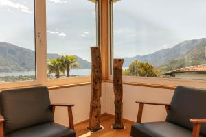 a room with two chairs and a large window at Casa Teatro Panoramico 5 Star Holiday House in Locarno
