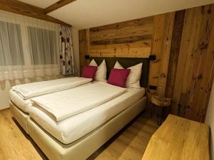 una camera da letto con un grande letto bianco con cuscini rossi di Ella's a Fusch an der Glocknerstrasse