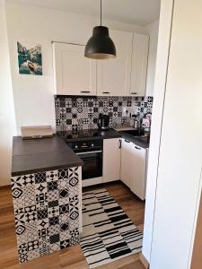 a kitchen with black and white tiles on the wall at Apartament Złoty Trójkąt z miejscem w garażu podziemnym in Serock