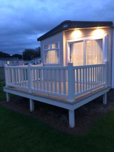a tiny house with a porch with lights on it at Lovely Caravan in Turnberry