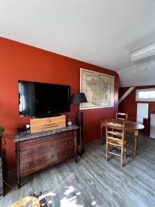 a living room with a flat screen tv and a table at Le Clos des Moulins 2 rue des cotes de l'Héry in Hautvillers