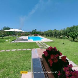 un patio con piscina y algunas flores en VILLA LAURO LUXURY B&B en Castellabate