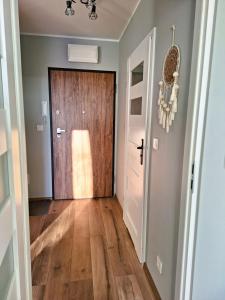 un pasillo con una puerta de madera en una casa en Apartament Złoty Trójkąt z miejscem w garażu podziemnym en Serock