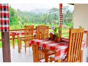 a dining room with a table and chairs and a window at Gongwi Cottages Sidemen in Sidemen