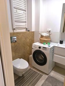 ein Badezimmer mit einer Waschmaschine und einem WC in der Unterkunft Apartament Złoty Trójkąt z miejscem w garażu podziemnym in Serock