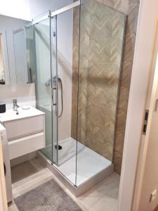 een douche met een glazen deur in de badkamer bij Apartament Złoty Trójkąt z miejscem w garażu podziemnym in Serock