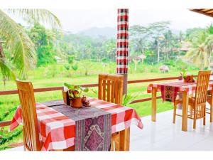 a porch with two tables and a view of a field at Gongwi Cottages Sidemen in Sidemen