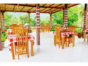 a restaurant with wooden tables and chairs with red and white stripes at Gongwi Cottages Sidemen in Sidemen