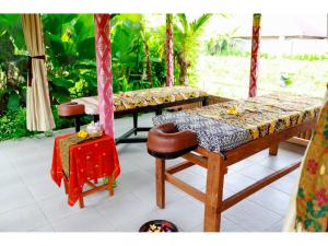 a porch with two benches and a table at Gongwi Cottages Sidemen in Sidemen