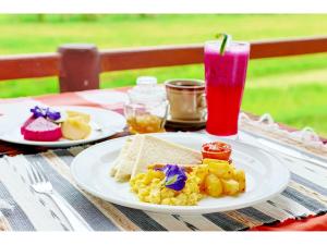 a table with a plate of breakfast food and a drink at Gongwi Cottages Sidemen in Sidemen
