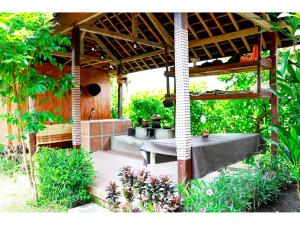 a patio with a table under a pergola at Gongwi Cottages Sidemen in Sidemen
