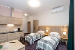 a hotel room with two beds and a kitchen at Moja Accommodation in Kaunas