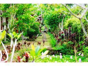 a path through a garden with trees and flowers at Gongwi Cottages Sidemen in Sidemen