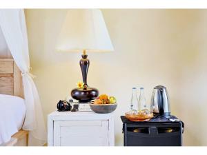 a table with a lamp and a bowl of fruit on it at Gongwi Cottages Sidemen in Sidemen