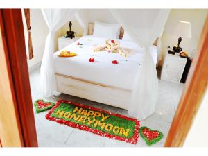 a bedroom with a bed with a happy anniversary sign on the floor at Gongwi Cottages Sidemen in Sidemen