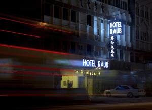 HOTEL RAUB since 1968 في راوب: مبنى الفندق عليه لافتات نيون جانبيه