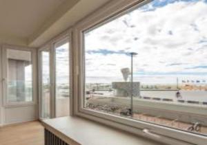 una camera con una grande finestra con vista sull'oceano di Manon Knokke - appartement met zeezicht aan het Rubensplein a Knokke-Heist