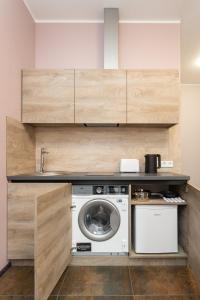 a laundry room with a washer and a washing machine at Moja Accommodation in Kaunas