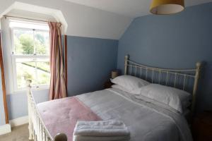 a bedroom with a large bed with a window at Cotswolds cottage near Stroud, with amazing views. in Brimscombe