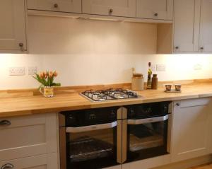 a kitchen with a stove and a counter top at Cotswolds cottage near Stroud, with amazing views. in Brimscombe