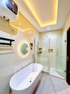 uma casa de banho branca com uma banheira e um chuveiro em Newly built Smart 4 bed rooms duplex in Ilasan ikate lekki em Lekki