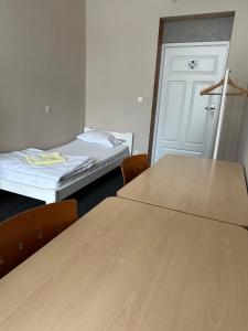 a room with two tables and two beds in it at Chilli Hostel in Wrocław