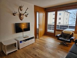 a living room with a television and a chair at Sonnenzauber in Andermatt