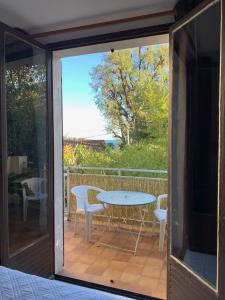 un porche cubierto con mesa y sillas en Maison Les Mimosas en Rayol-Canadel-sur-Mer