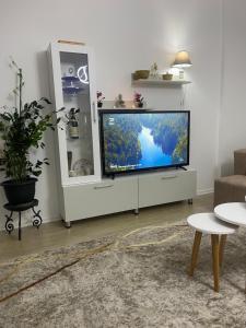 a living room with a flat screen tv on a white cabinet at Access apartment in Tirana