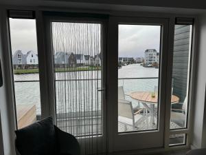 a glass door with a view of the water at Boothuis Harderwijk in Harderwijk