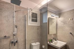 a bathroom with a shower and a toilet and a sink at Loutraki Hidden Gem IV in Loutraki