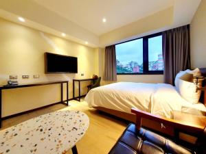 Habitación de hotel con cama y TV de pantalla plana. en 享住新大華館 en Keelung