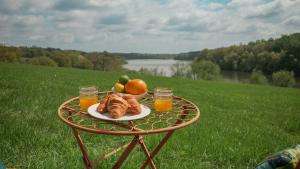 a table with a plate of croissants and fruit on it at Quirky Vintage Horsebox Truck in Balcombe