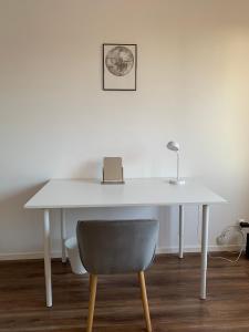 a white desk with a chair and a lamp at Kat &Suzie in Suwałki