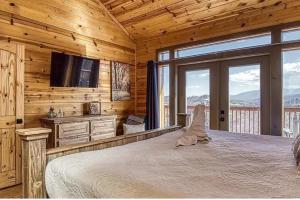 a bedroom with a bed and a flat screen tv at Hawk’s View Log Cabin -Mountains in Gatlinburg. in Gatlinburg
