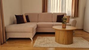 ein Wohnzimmer mit einem Sofa und einem Tisch in der Unterkunft Апартамент Ния, Райска градина / Garden of Eden in Sweti Wlas