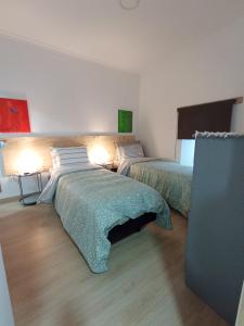 1 Schlafzimmer mit 2 Betten und 2 Lampen an der Wand in der Unterkunft Casa Ocre Alojamento Local in Abrantes